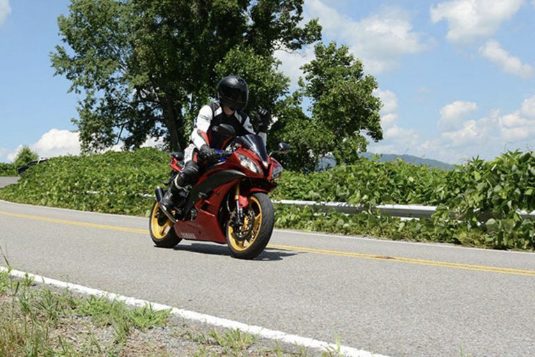 Motorcycle riding through vibrant fall foliage on Back of the Dragon in Virginia